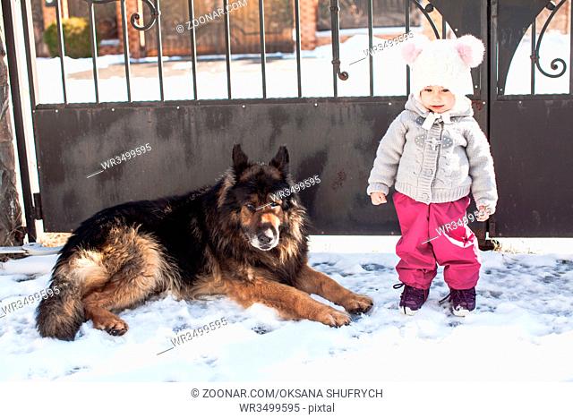 Little girl talking with her dog on winter walk