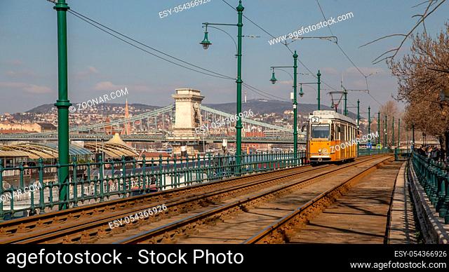 Budapest, Hungary, March 22 2018: Yellow Tram in early winter with cloudy sky. Tram number 2 is famous for being the best european line selected by National...