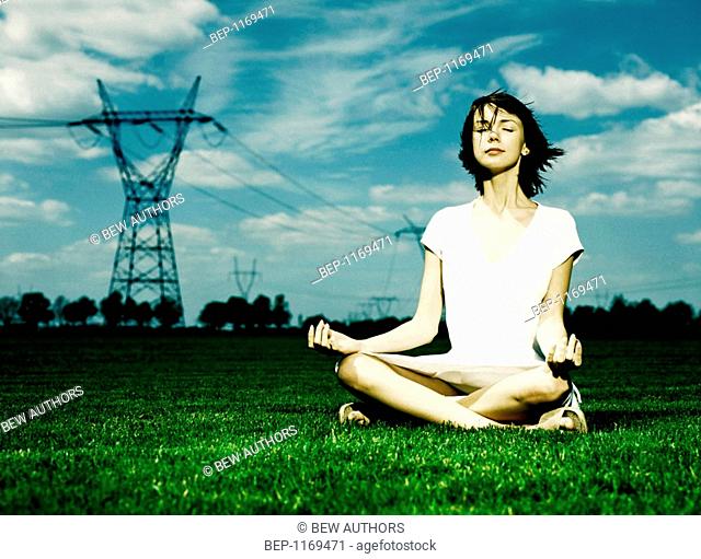 Woman meditating on meadow
