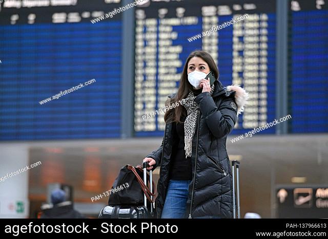 Themed picture trips in times of the corona pandemic. Young woman with face mask, mask at Munich Airport on December 6th, 2020