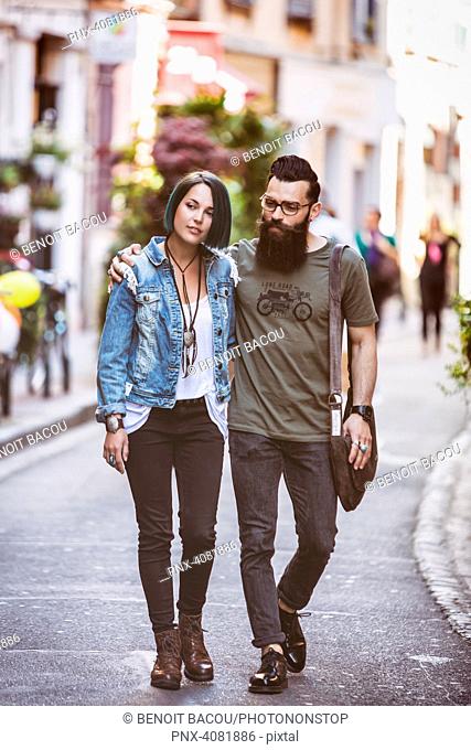 Young hipster couple walking down the street