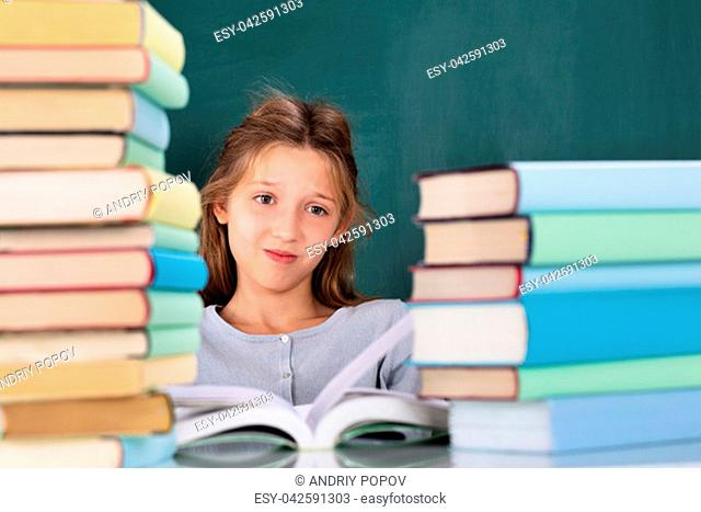 Close-up Of A Stressed Student Looking At Stack Of Books