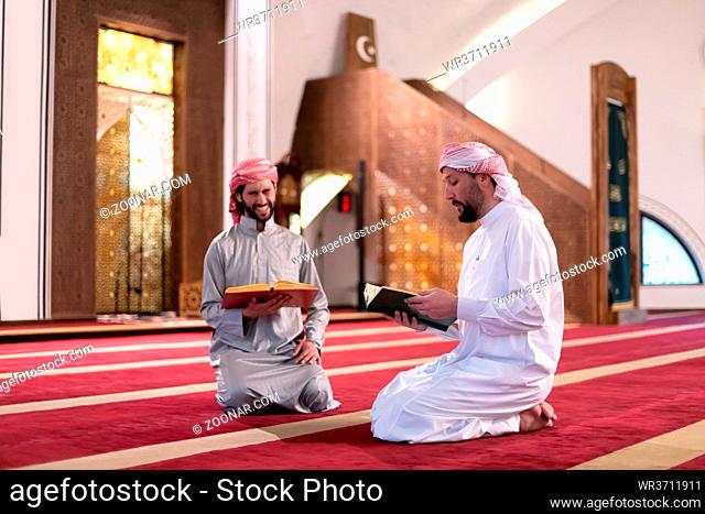 two muslim people in mosque reading quran together concept of islamic education and school of holly book kuran