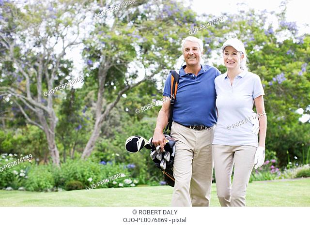Senior couple with golf clubs