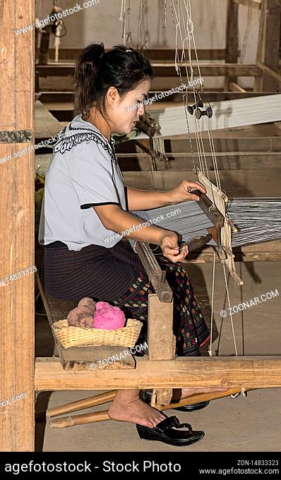 Junge Frau webt an einem traditionellen Lao-Thai Webstuhl, Ban Phanom, Laos / Young woamn weaving on a traditional Lao-Thai style loom, Ban Phanom, Laos
