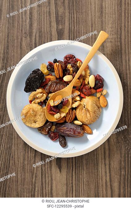 Dried fruit and nuts in a bowl with a wooden spoon