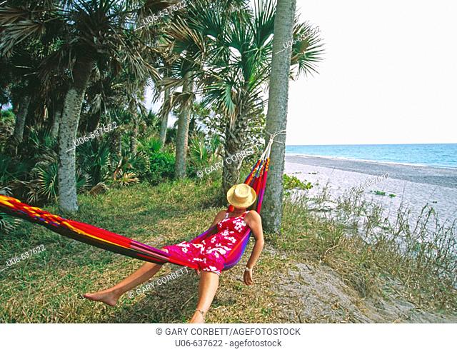 Woman with a hat covering her head in a hammock at Casperson beach at Venice, Florida (USA)
