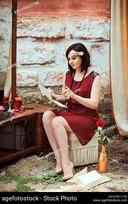 retro girl sitting at a dressing table and reading a letter