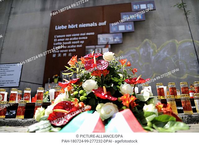24 July 2018, Germany, Duisburg: Wreaths lie in front of the memorial for the victims of the Love Parade disaster. Family members gather for a memorial service...