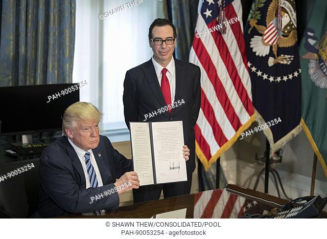 US President Donald J. Trump (L), with Secretary of Treasury Steven Mnuchin (R), displays a signed financial services Executive Order during a ceremony in the...
