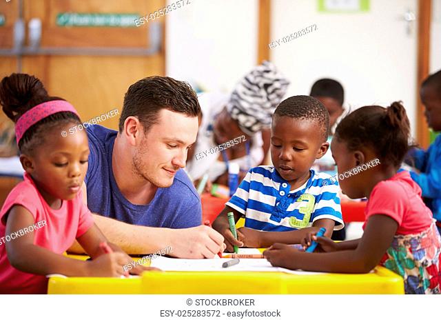 Volunteer teacher sitting with preschool kids in a classroom