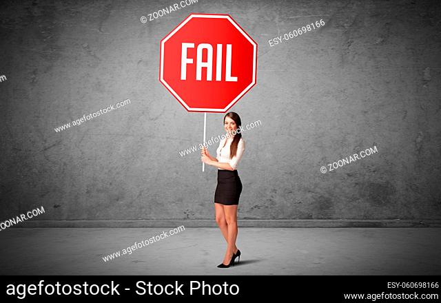 Young business person holding road sign with FAIL inscription, new rules concept