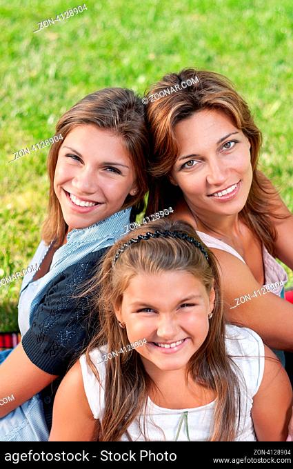 Happy mother with her daughters in park outdoors
