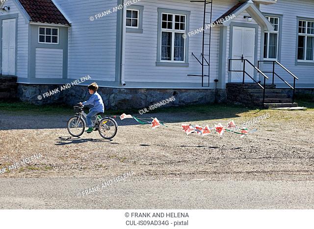 Boy riding bicycle pulling bunting