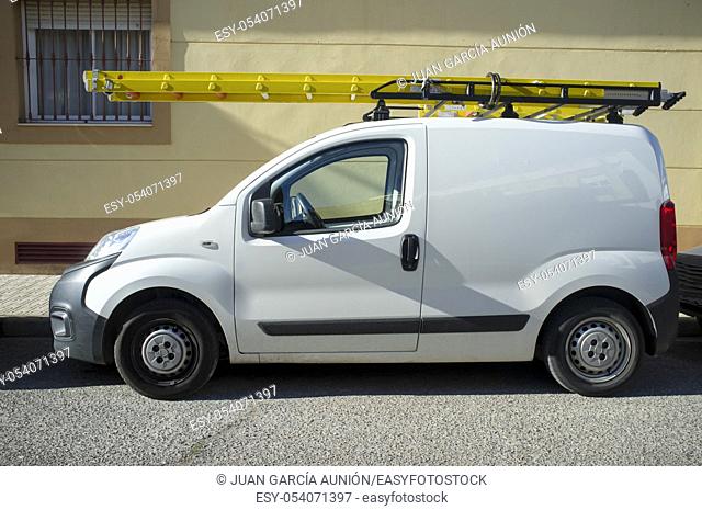 Delivery van loaded with yellow ladders. Home repair contractor van concept