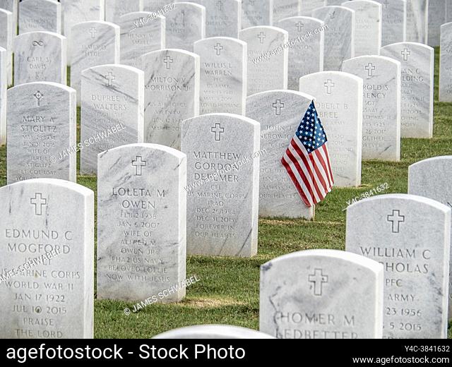 Lone American flag amoung grave stones in Sarasota National Cemetery in Sarasota Florida USA