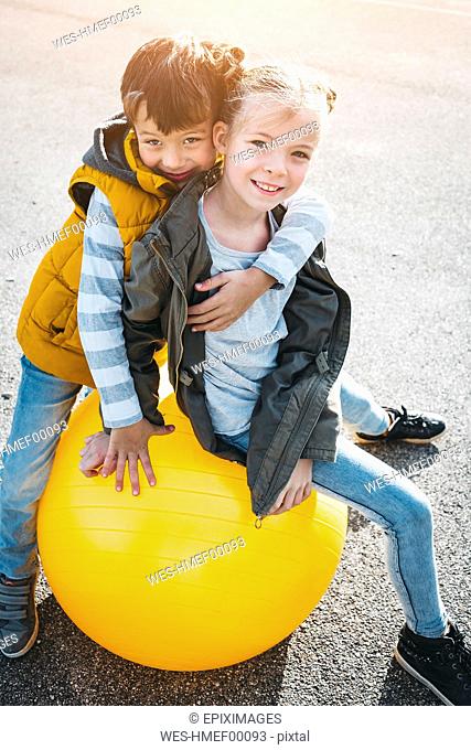 Portrait of two children having fun with gym ball