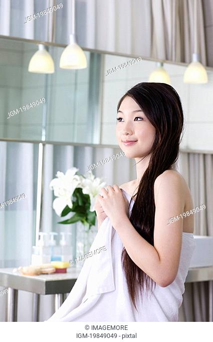 Young woman wearing a towel and looking away