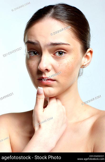 Emotional young woman face portrait with unhappy facial expression. Human female natural emotions and expressions concept