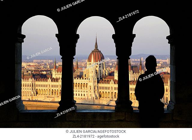 Silhouette of a woman watching the Hungarian Parliament Building from the Fisherman's Bastion at sunset. Hungary, Budapest. Model Released