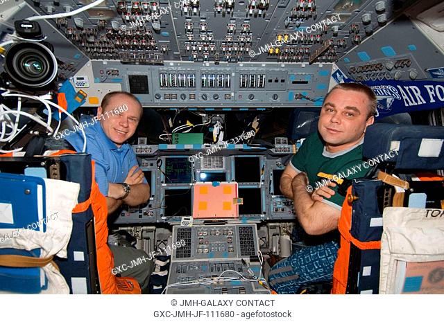 Russian cosmonauts Oleg Kotov (left) and Maxim Suraev, both Expedition 22 flight engineers, pose for a photo on the flight deck of space shuttle Endeavour while...