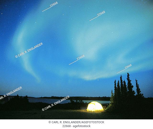 Northern Lights (aurora borealis) with lighted tent, Northwest Territories, Canada