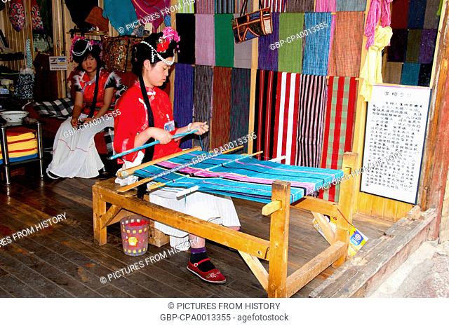 China: Mosuo woman weaving in Lijiang Old Town, Yunnan Province