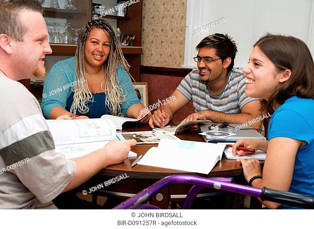 Multiracial group of students in study group, one has cerebral palsy and uses a walking frame