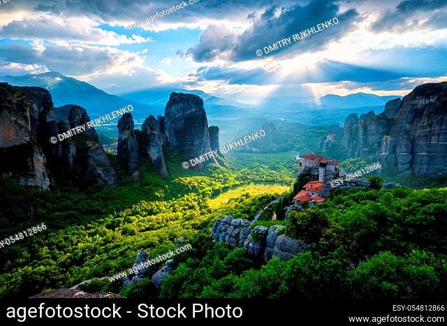 Sunset over monastery of Rousanou and Monastery of St. Nicholas Anapavsa in famous greek tourist destination Meteora in Greece on sunset with sun rays and lens...