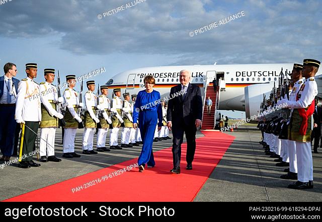 16 February 2023, Malaysia, Kuala Lumpur: German President Frank-Walter Steinmeier (r) and his wife Elke Büdenbender (L) are welcomed by a guard of honor on...