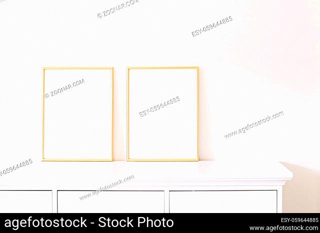 Two golden vertical frames on white furniture, luxury home decor and design for mockup creations