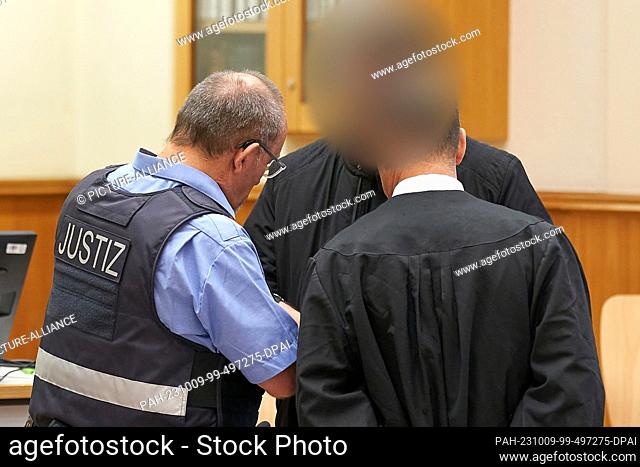 09 October 2023, Rhineland-Palatinate, Koblenz: The defendant (M) is led into the courtroom of the Higher Regional Court for the announcement of the verdict