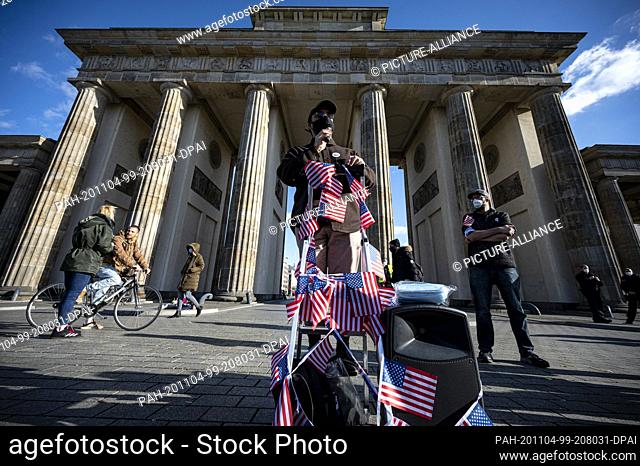 04 November 2020, Berlin: A participant wearing a mouth and nose protector speaks at a rally at the Brandenburg Gate under the motto ""Peaceful Transition of...