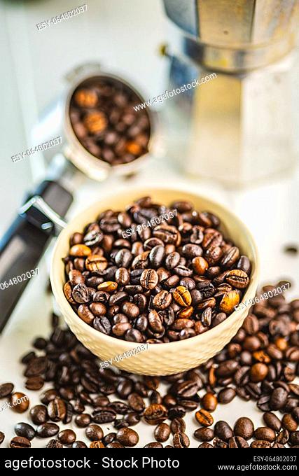 Roasted coffee beans in bowl on the white kitchen table