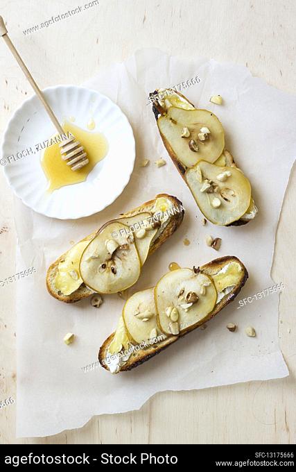 Toasts with camembert cheese, pears, walnuts and honey