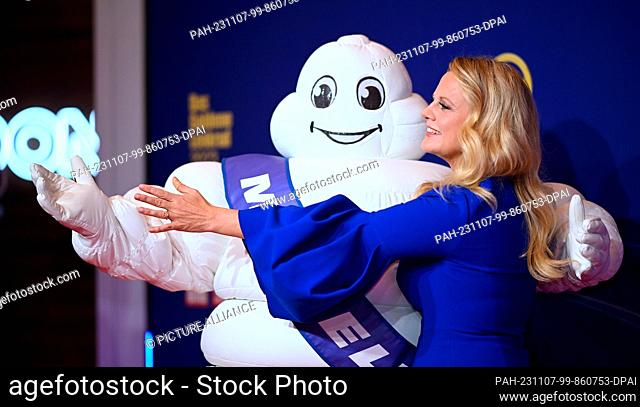 07 November 2023, Berlin: Barbara Schöneberger, presenter, arrives at the ""Golden Steering Wheel 2023"" award ceremony and poses with a Michelin man