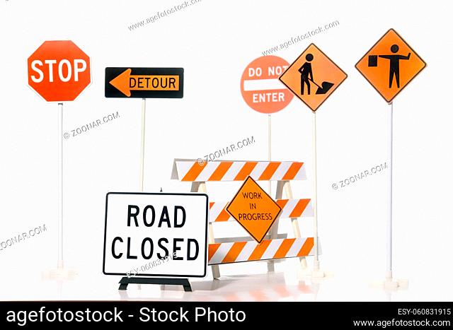 Construction warning barriers and road construction signs over white background