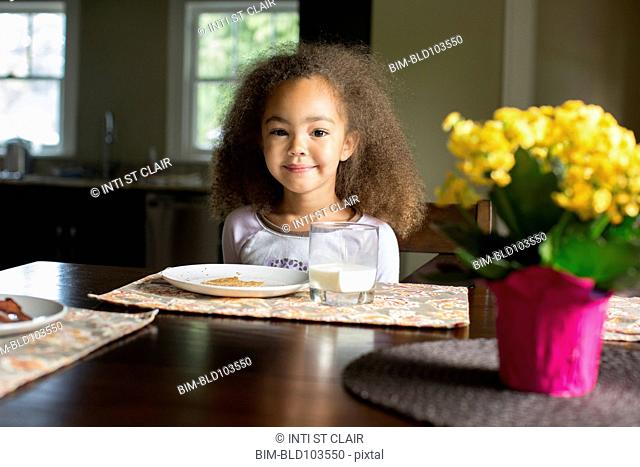 Mixed race girl eating breakfast