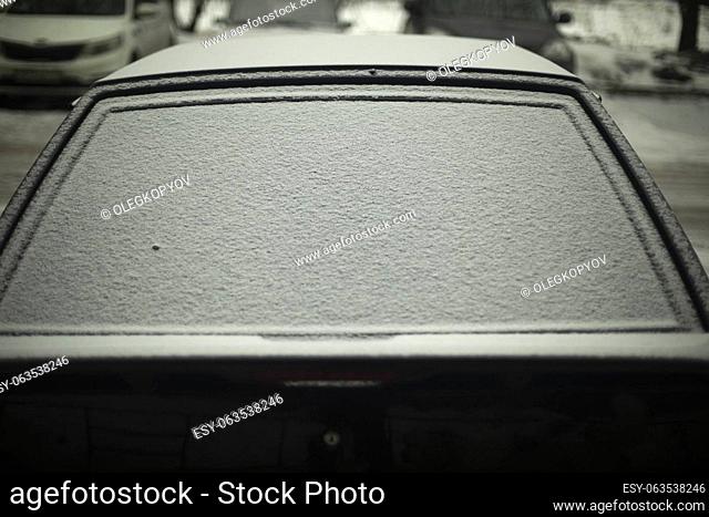 Rear window of car in snow. Snow by car. Car is parked in winter. Snow on glass