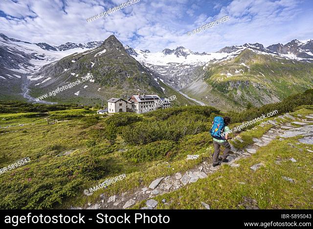 Hiker in front of the Berliner Hütte, behind the Waxeggkees Glacier, Berliner Höhenweg, Zillertal Alps, Zillertal, Tyrol, Austria, Europe