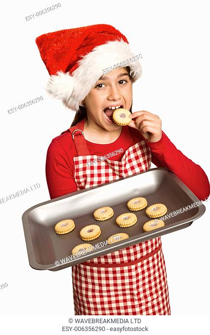 Festive little girl offering cookies on white background