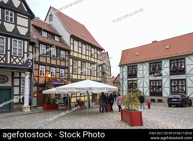 29 November 2020, Saxony-Anhalt, Quedlinburg: Christmassy decorated alleys, facades and fairy lights create an Advent atmosphere in the old town