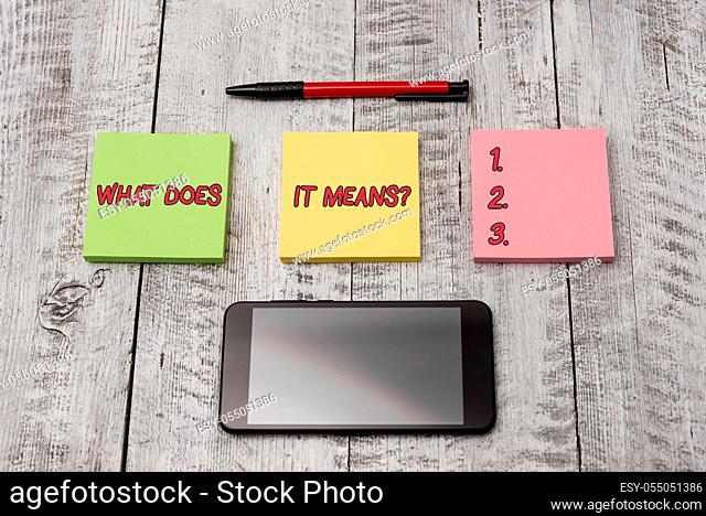 Writing note showing What Does It Means question. Business concept for asking meaning something said and do not understand Stationary equipment and phone with...