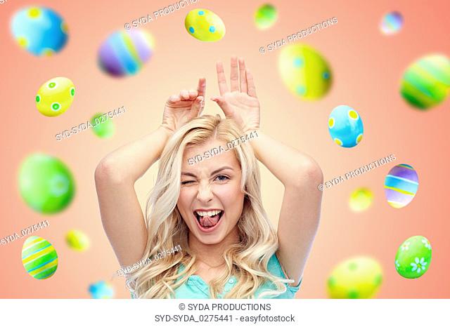 happy smiling young woman making easter bunny ears
