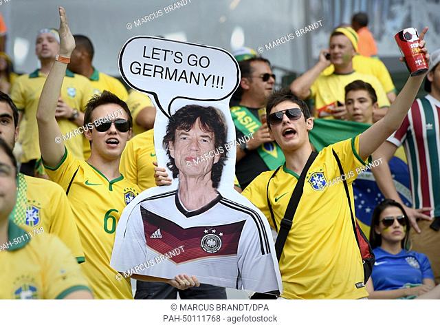 Brazilian supporters hold a banner depicting Mick Jagger saying Let's go Germany during the FIFA World Cup 2014 semi-final soccer match between Brazil and...
