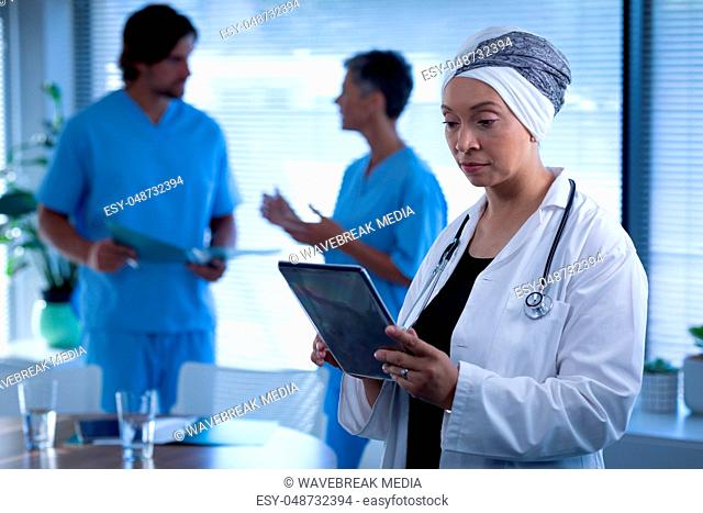 Female doctor looking at digital tablet in clinic at hospital
