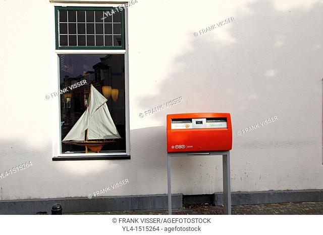Dutch mailbox in front of window with sailing boat. Terschelling, Netherlands