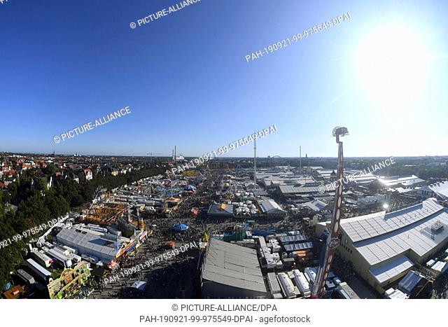 21 September 2019, Bavaria, Munich: Start of the Oktoberfest. The sun shines under a blue sky over the Oktoberfest and the Theresienwiese