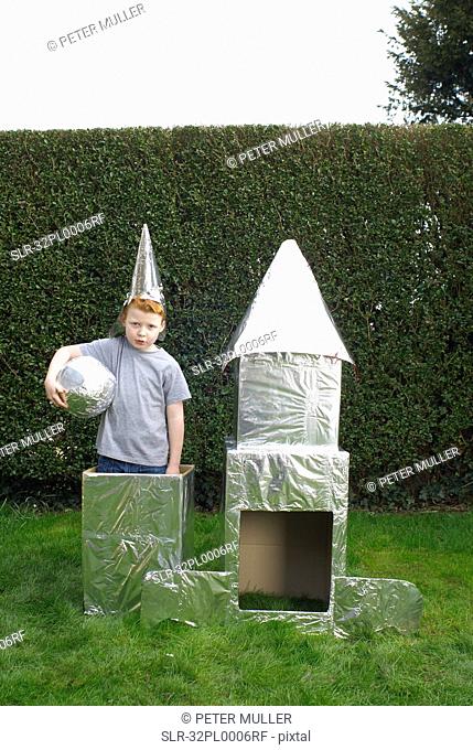 Boy playing with cardboard spaceship