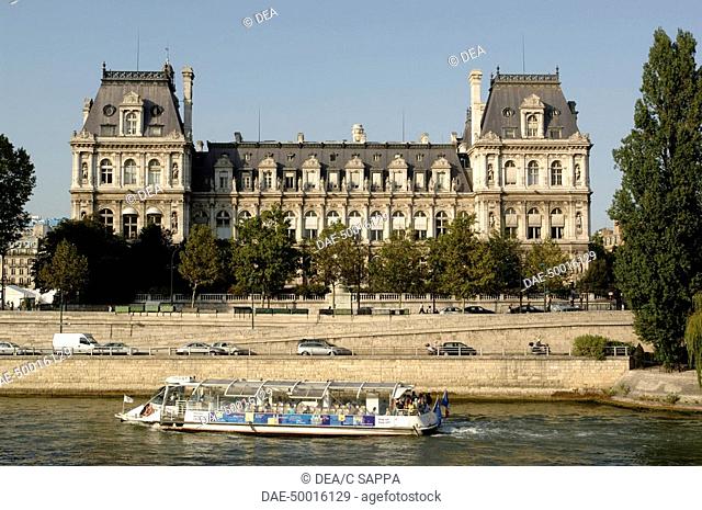 France - Ile-de-France - Paris. Scenic boat 'bateau mouche' cruises Seine along Quai de l'Hotel de Ville (City Hall). UNESCO World Heritage List, 1991